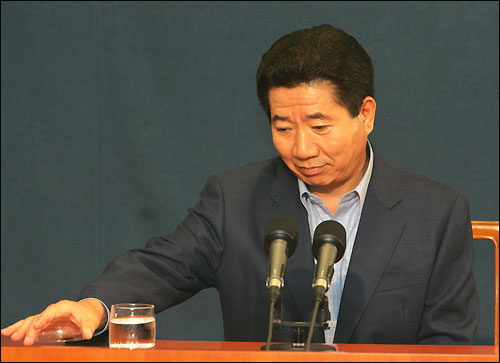 지난 2005년 8월 8일 오전 노무현 대통령이 청와대 춘추관에서 국정원 불법도청 관련 기자간담회를 하는 도중 물컵 뚜껑을 열고 있다.